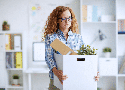 Eine enttäuscht aussehende Frau trägt einen Umzugskarton