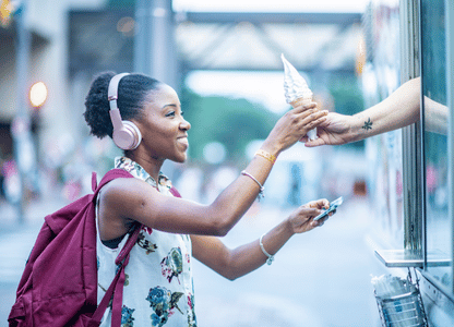 A woman buys soft serve ice cream from a food truck