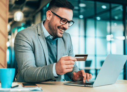 A man paying something on his laptop with his credit card