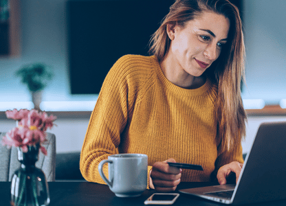 A woman paying something at her laptop